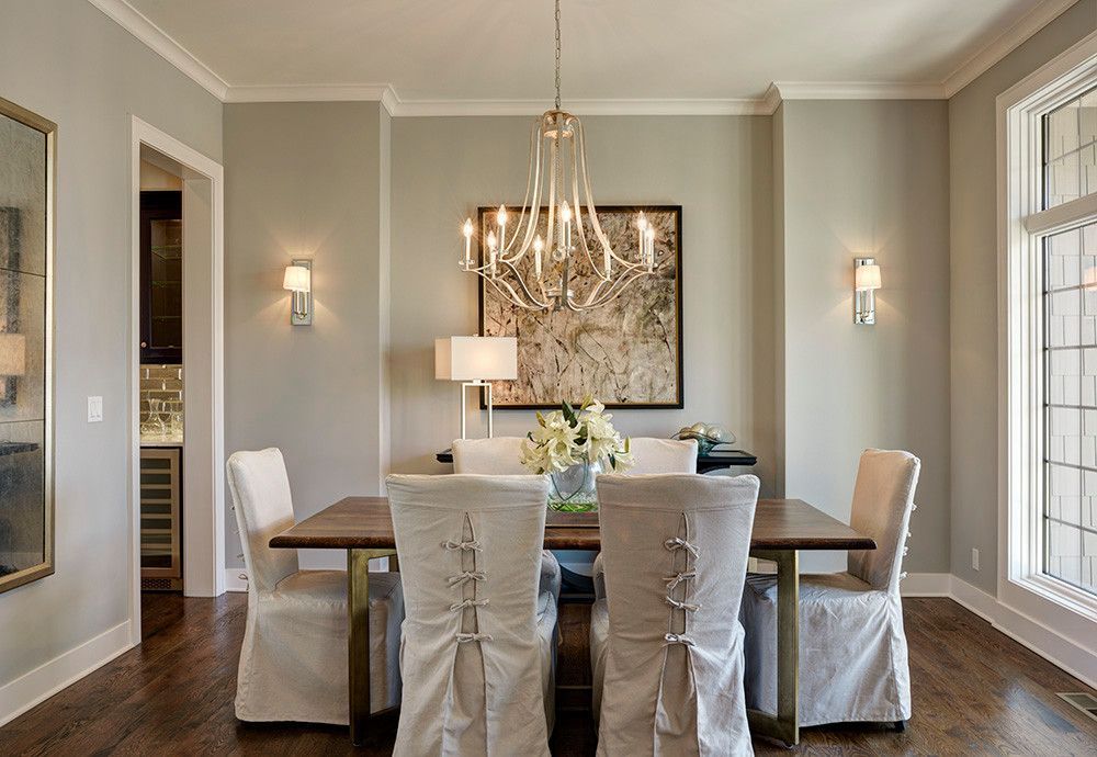A dining room with a table and chairs and a chandelier