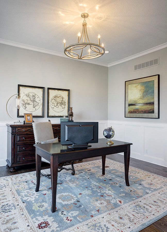 A home office with a desk, chair, computer and rug