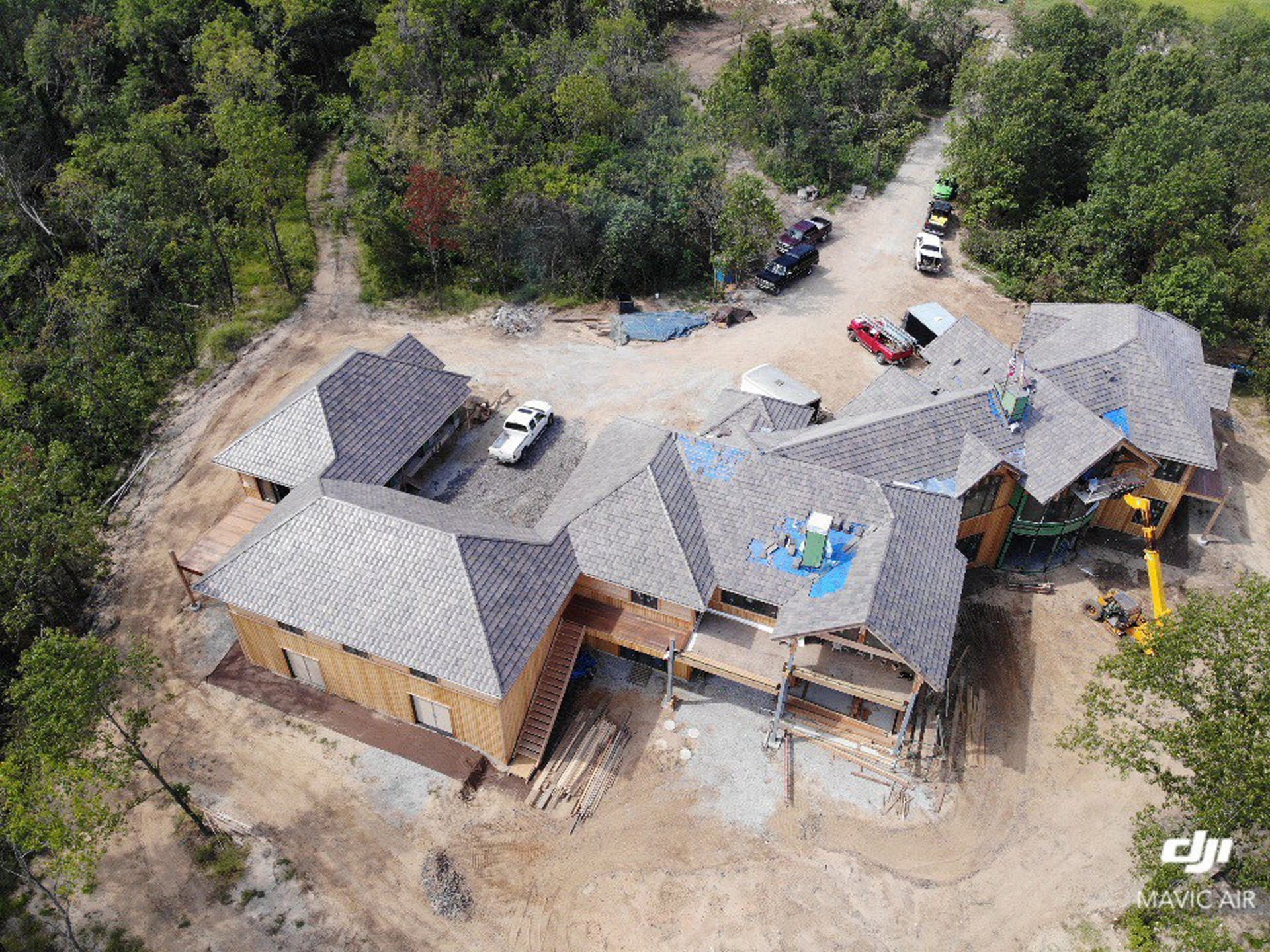 An aerial view of a house under construction in the middle of a forest