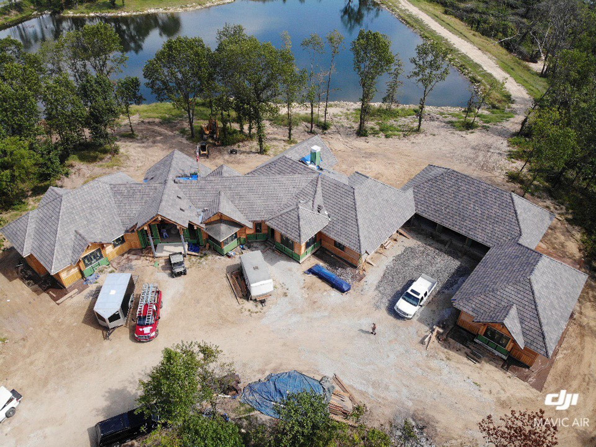An aerial view of a house under construction next to a lake