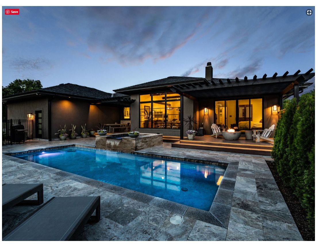 A house with a large swimming pool in front of it