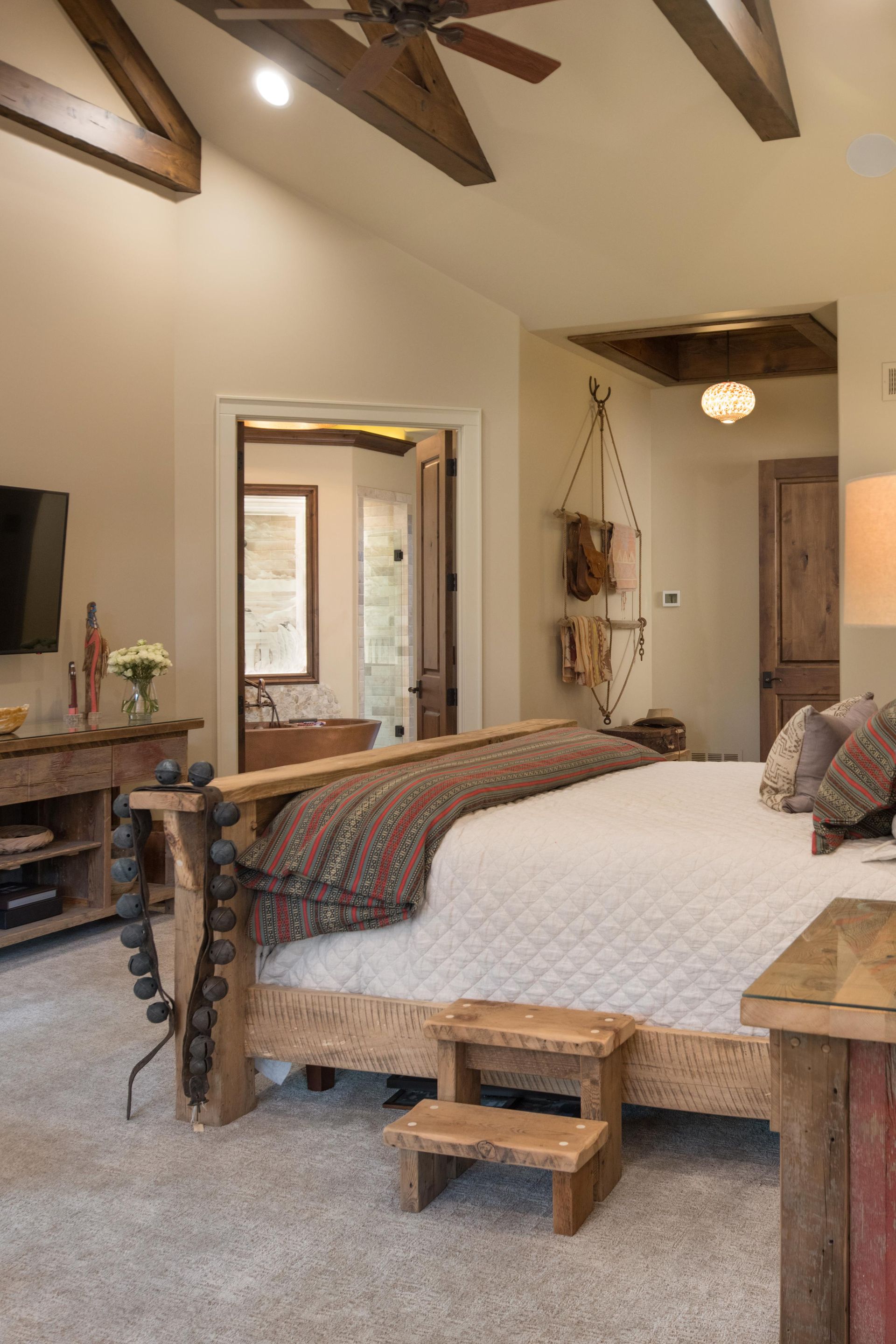 A bedroom with a large bed and a ceiling fan.