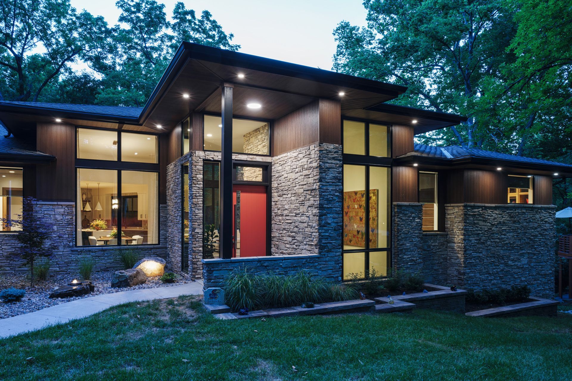 A modern house with a red door and lots of windows