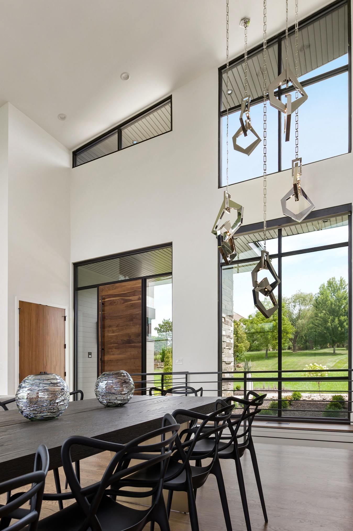 A dining room with a table and chairs and a large window.
