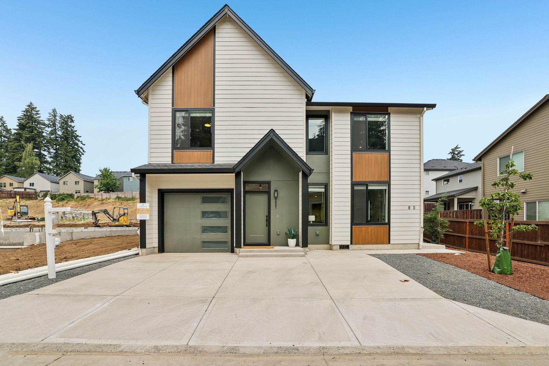 Modern two-story house with a garage, front walkway, and landscaped yard