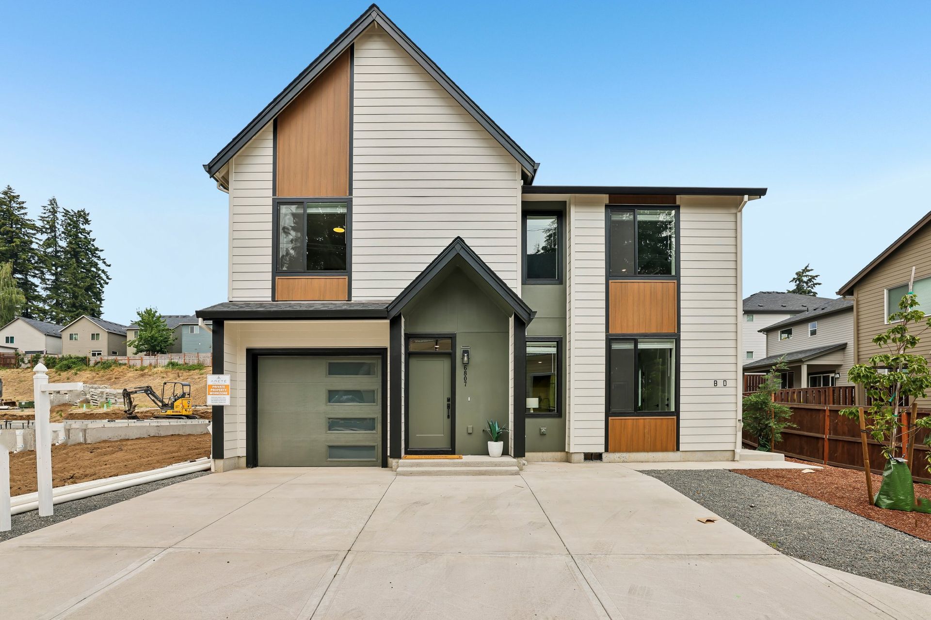 Modern two-story suburban house with driveway, garage, and front entry under clear sky