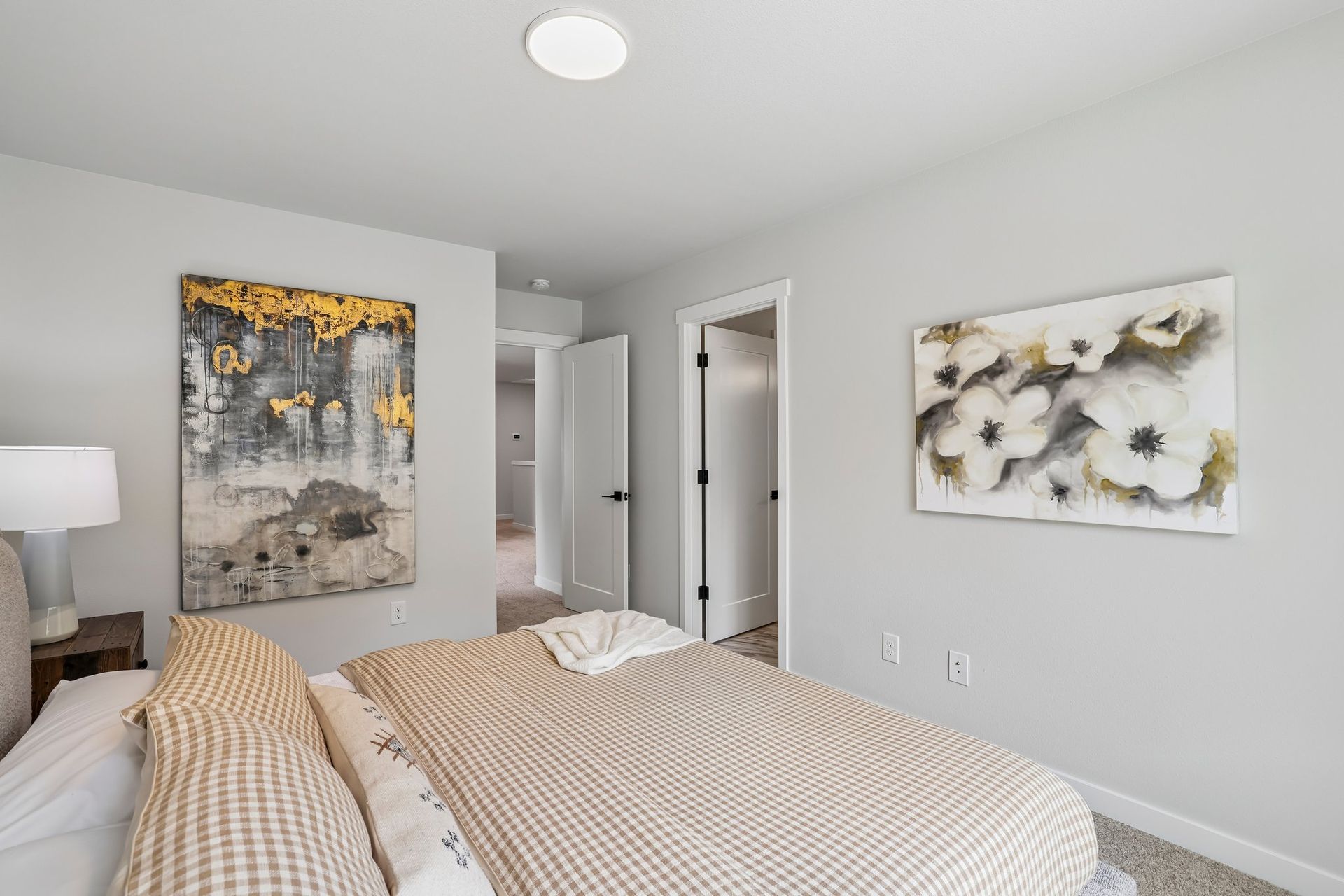 Bright bedroom with twin beds, gray walls, abstract art, and floral wall decor