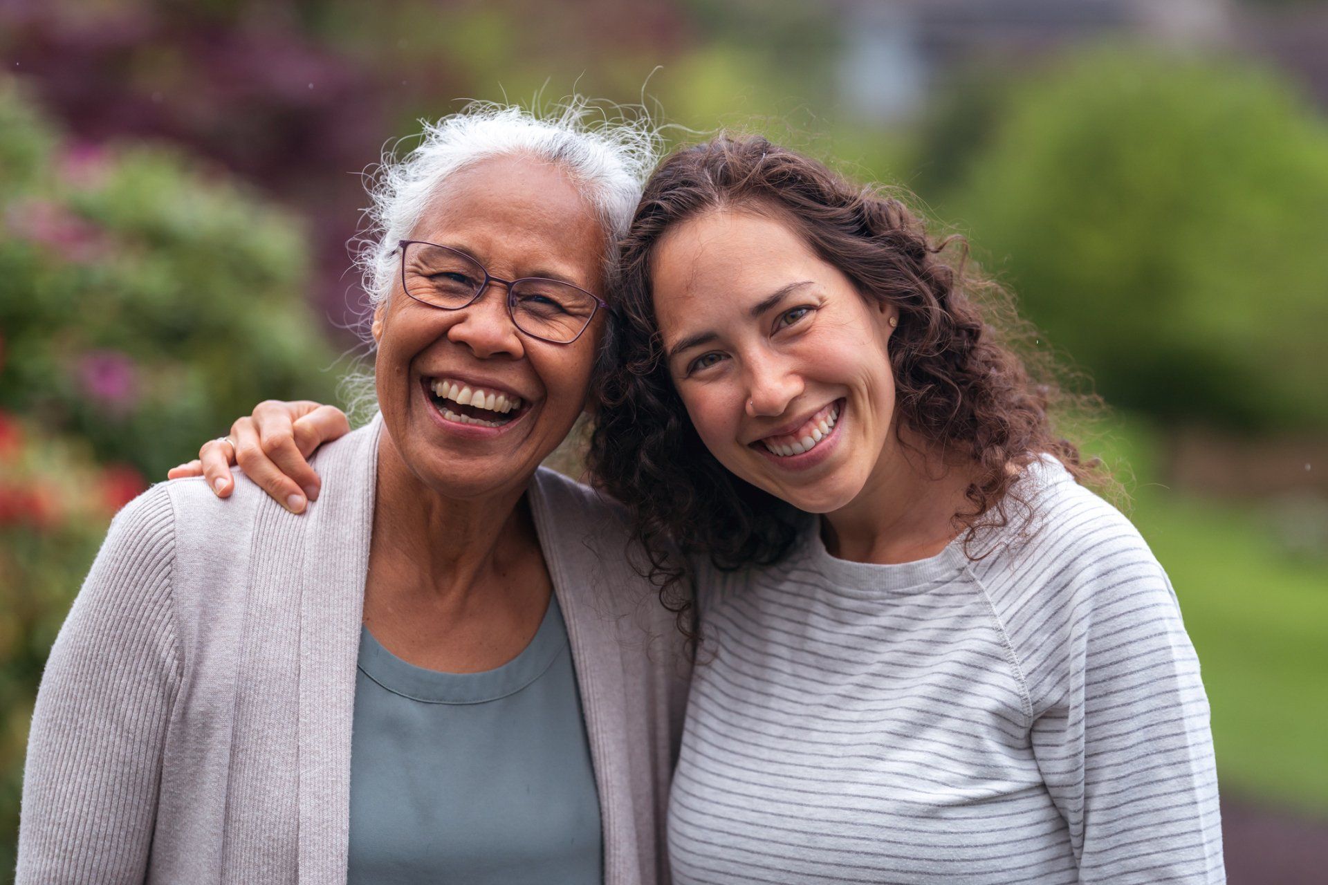 An older woman and a younger woman are posing for a picture together.
