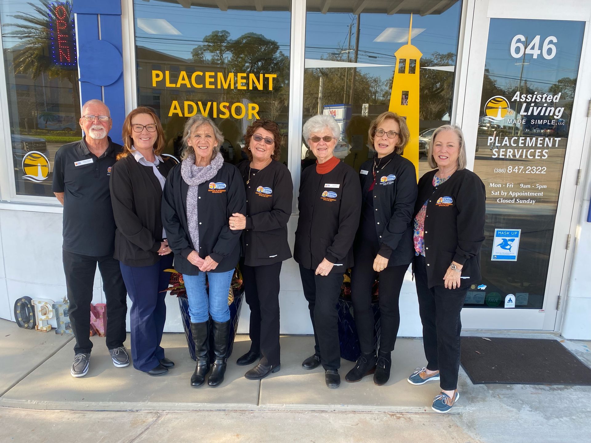 A group of people standing in front of a building that says placement advisor