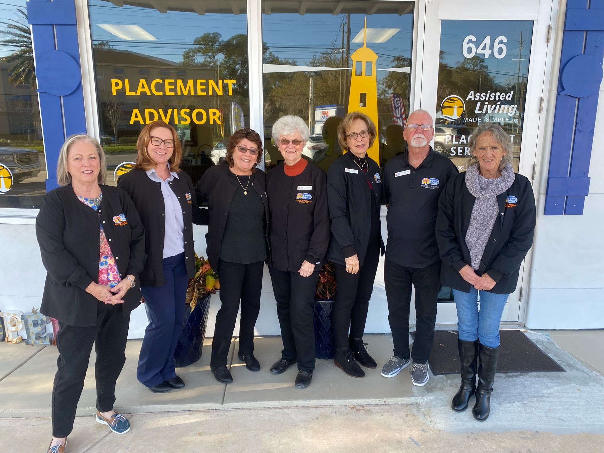 A group of people standing in front of a building that says placement advisor