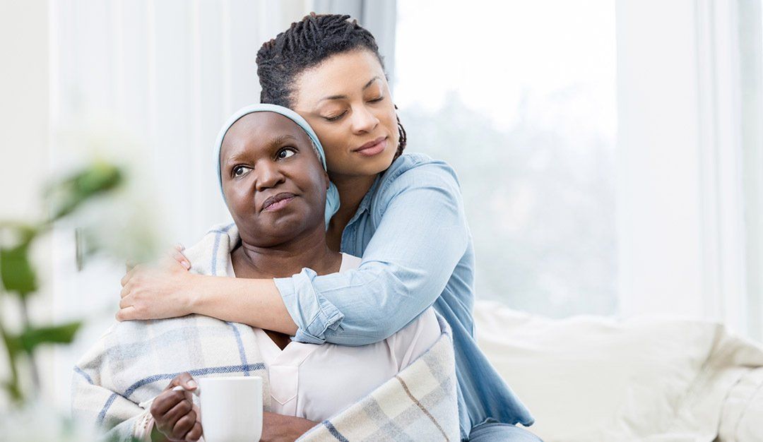 A woman is hugging an older woman on a couch.