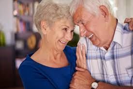 A man and a woman are hugging each other and smiling.