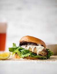 A close up of a hamburger on a bun on a table.