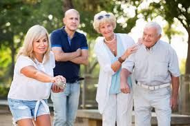 A group of people are playing bocce ball in a park.
