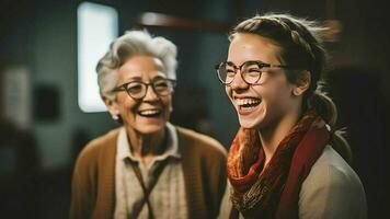 An elderly woman and a young woman are laughing together.