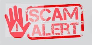 A red stamp with the words scam alert written on it