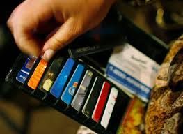 A person is holding a wallet full of credit cards.