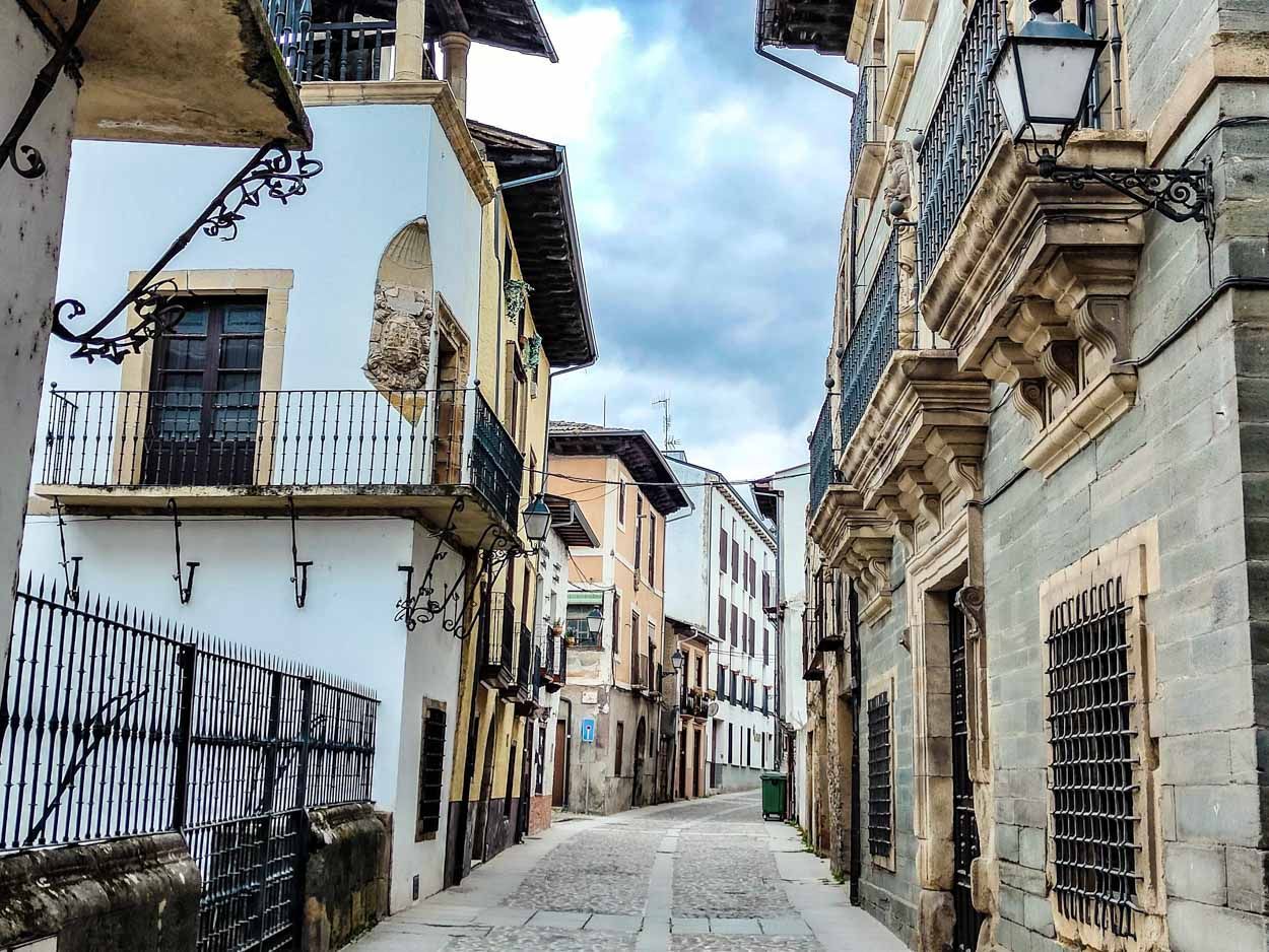 Narrow cobblestone street lined with old buildings in Spain.