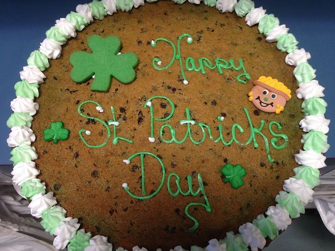 Chocolate cake with green frosting reading “Happy St. Patrick’s Day” and shamrock decorations