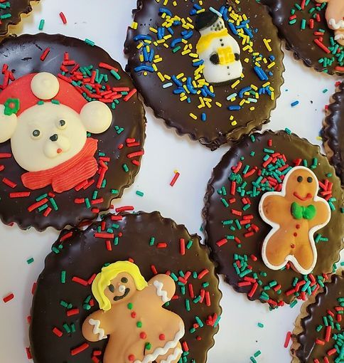Chocolate-covered holiday cookies with festive sprinkles and gingerbread, snowman, and bear decorations