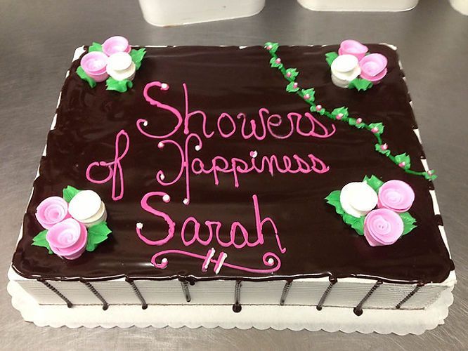 Chocolate cake with pink flowers and icing reading “Showers of Happiness Sarah”