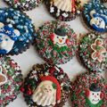Assorted decorated holiday cakes and cookie wreaths with red, green, and white frosting on a tray
