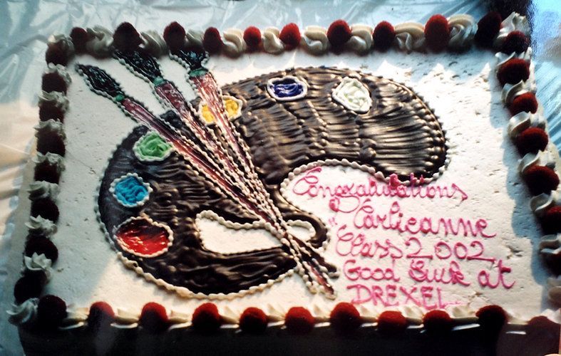 Decorated rectangular cake with painted palette, brushes, and pink writing on white frosting.