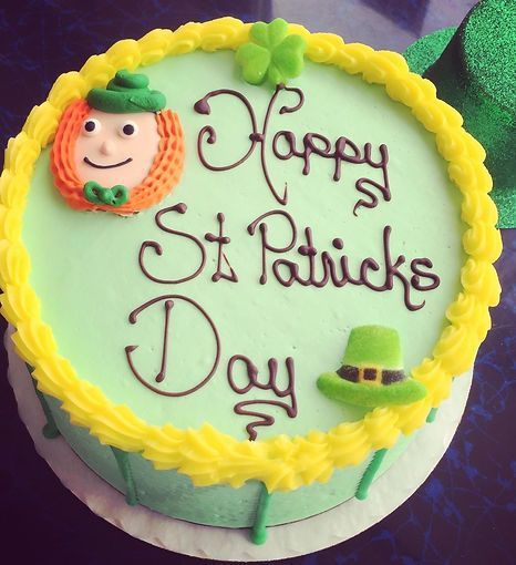 Green-and-yellow cake with “Happy St. Patrick’s Day” icing and a small leprechaun face decoration
