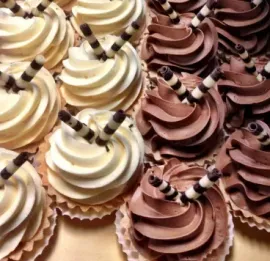 Assorted chocolate and vanilla frosted cupcakes topped with striped wafer rolls