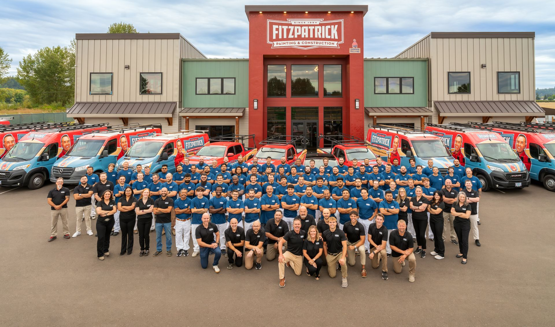 A large group of people are posing for a photo in front of a building that says 30 years