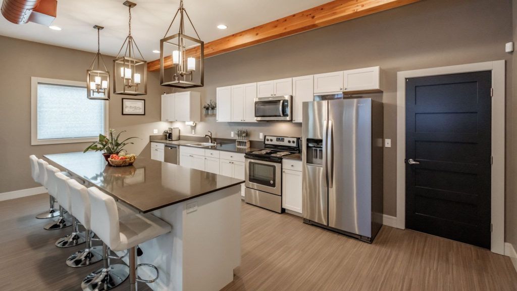 A kitchen with stainless steel appliances and a large island.