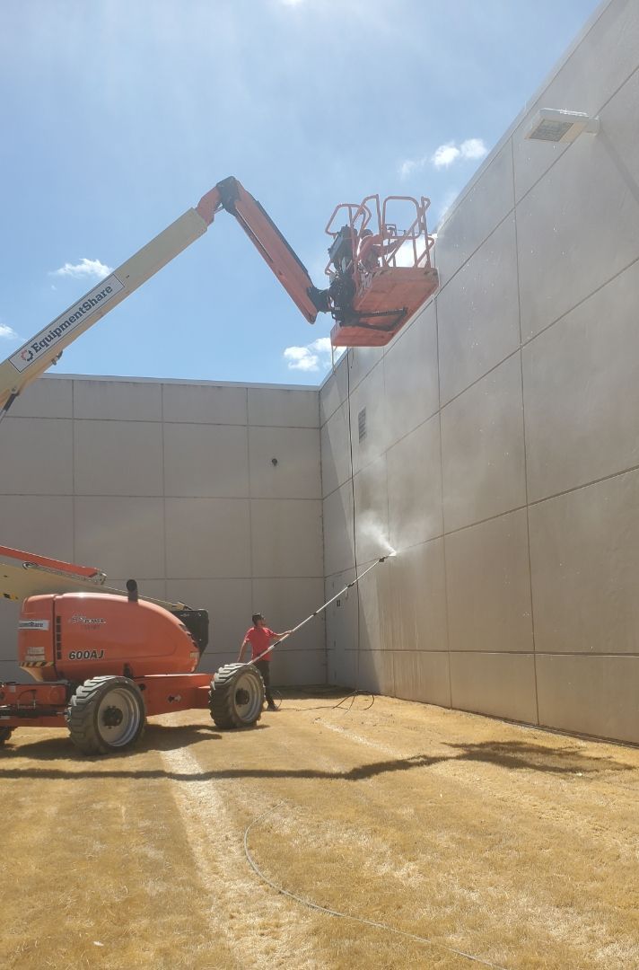 A man is cleaning a wall with a machine.