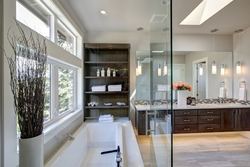 Modern bathroom with a soaking tub, shelving, and double sinks, with glass shower door.
