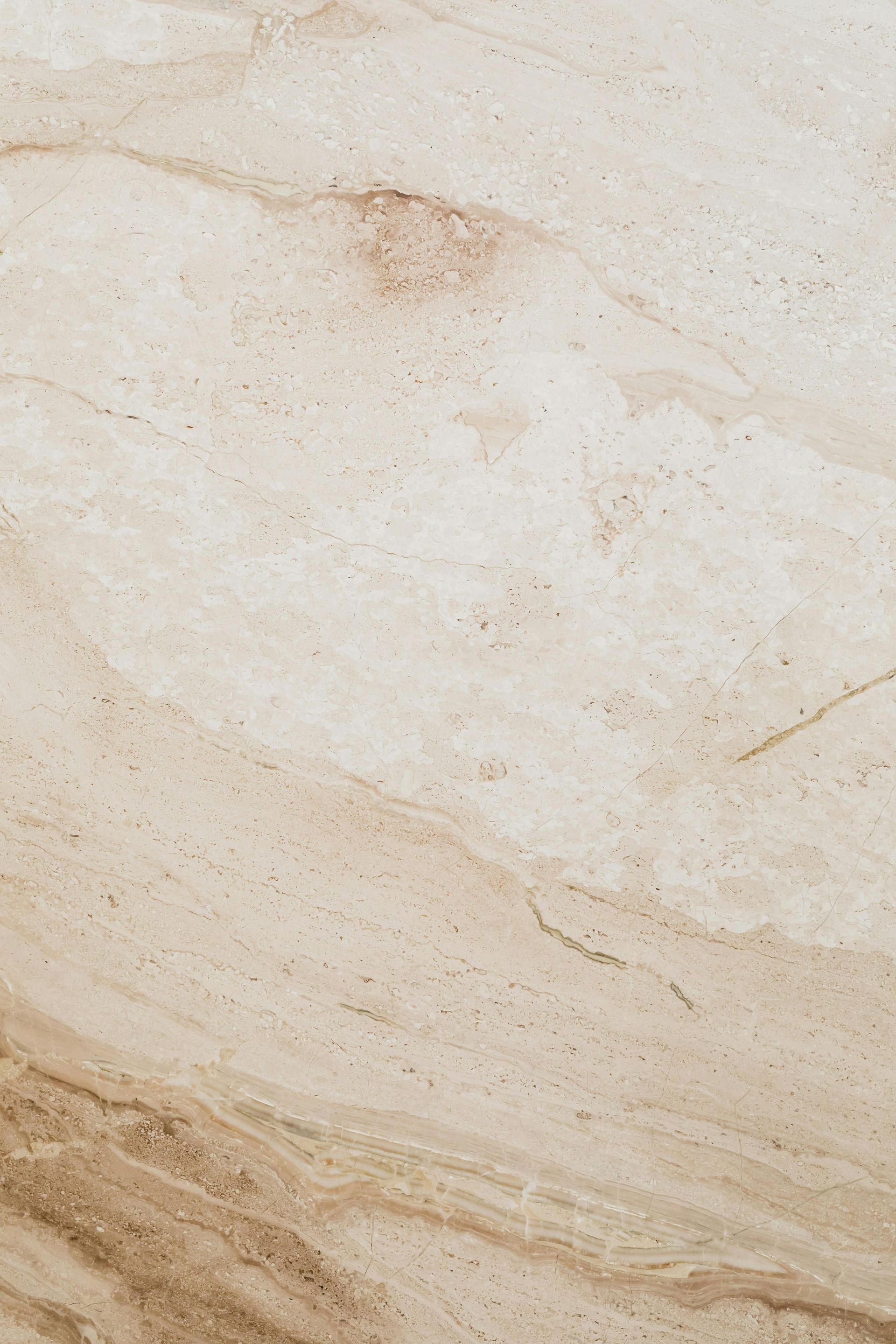 Cream-colored marble with tan and brown veining, slight granular texture.