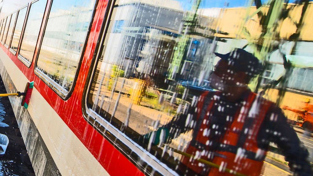 Eine Person spiegelt sich im Fenster eines Zuges.