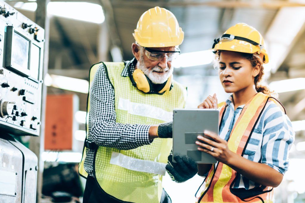 Two manufacturing employees looking at a tablet