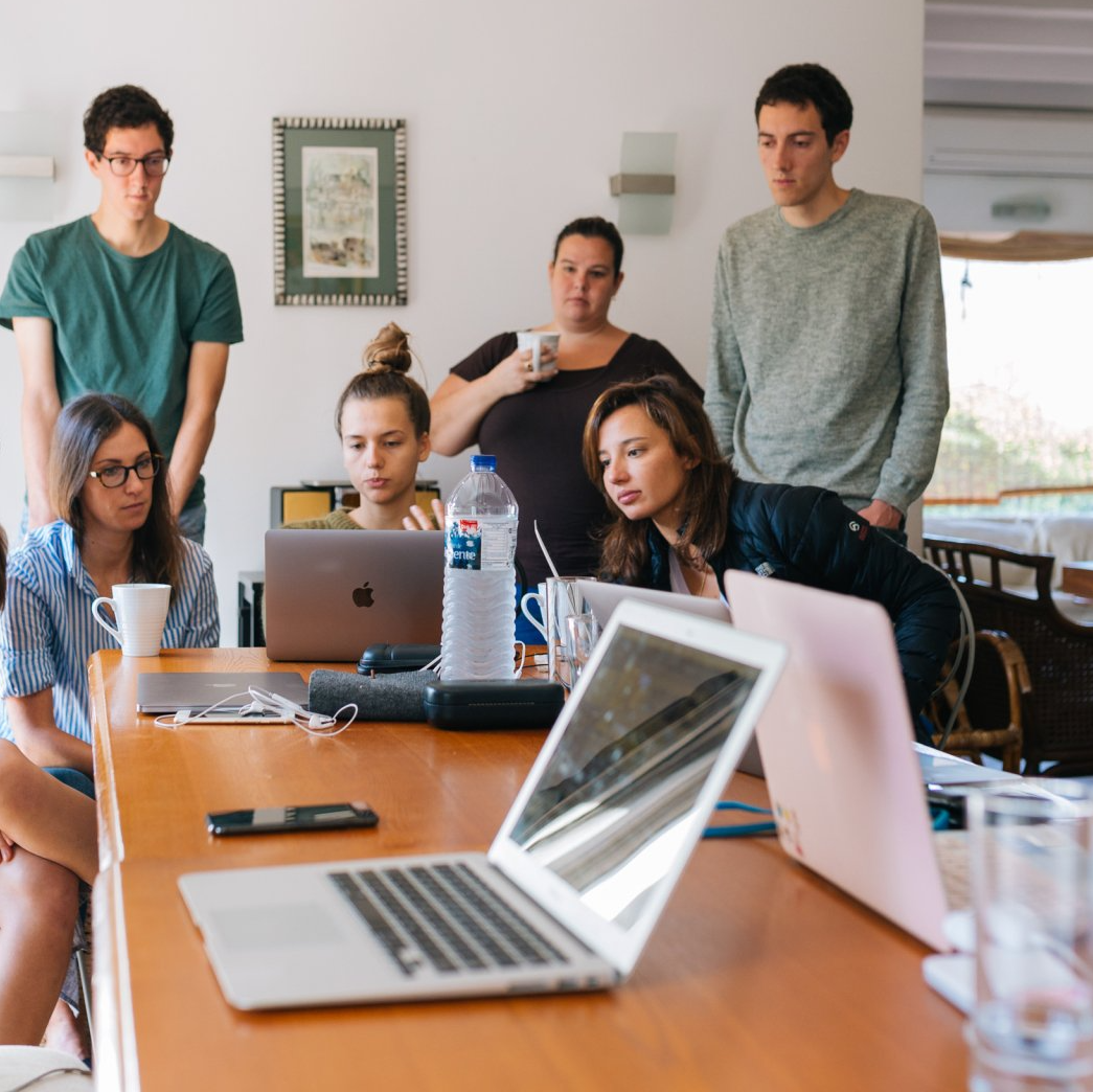 Employees gathered around a laptop