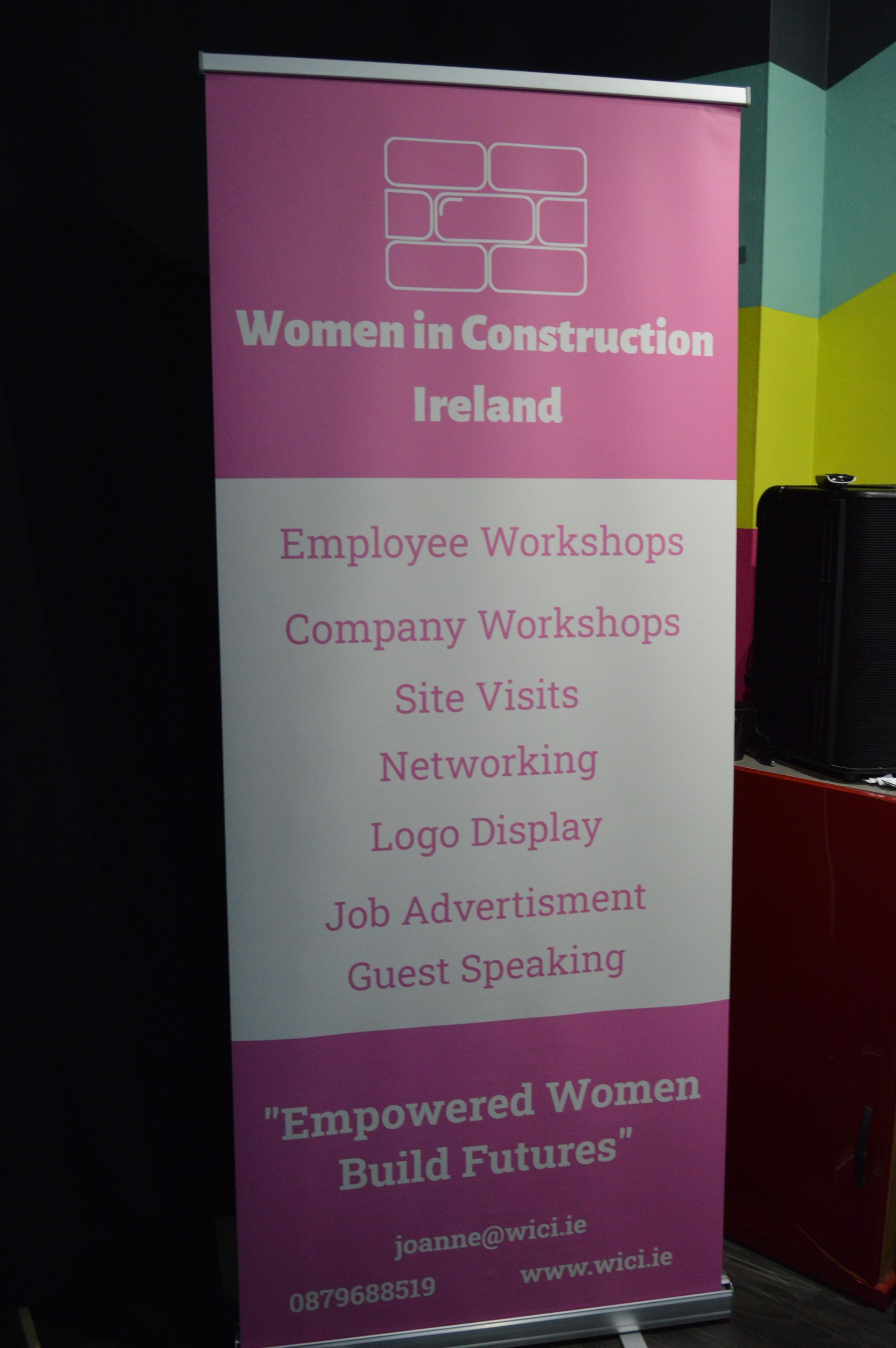 Pink “Women in Construction Ireland” banner listing workshops, networking, and guest speaking activities