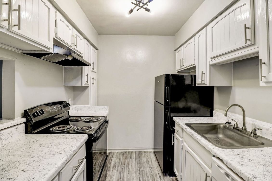 a kitchen with a black stove top oven and black cabinets