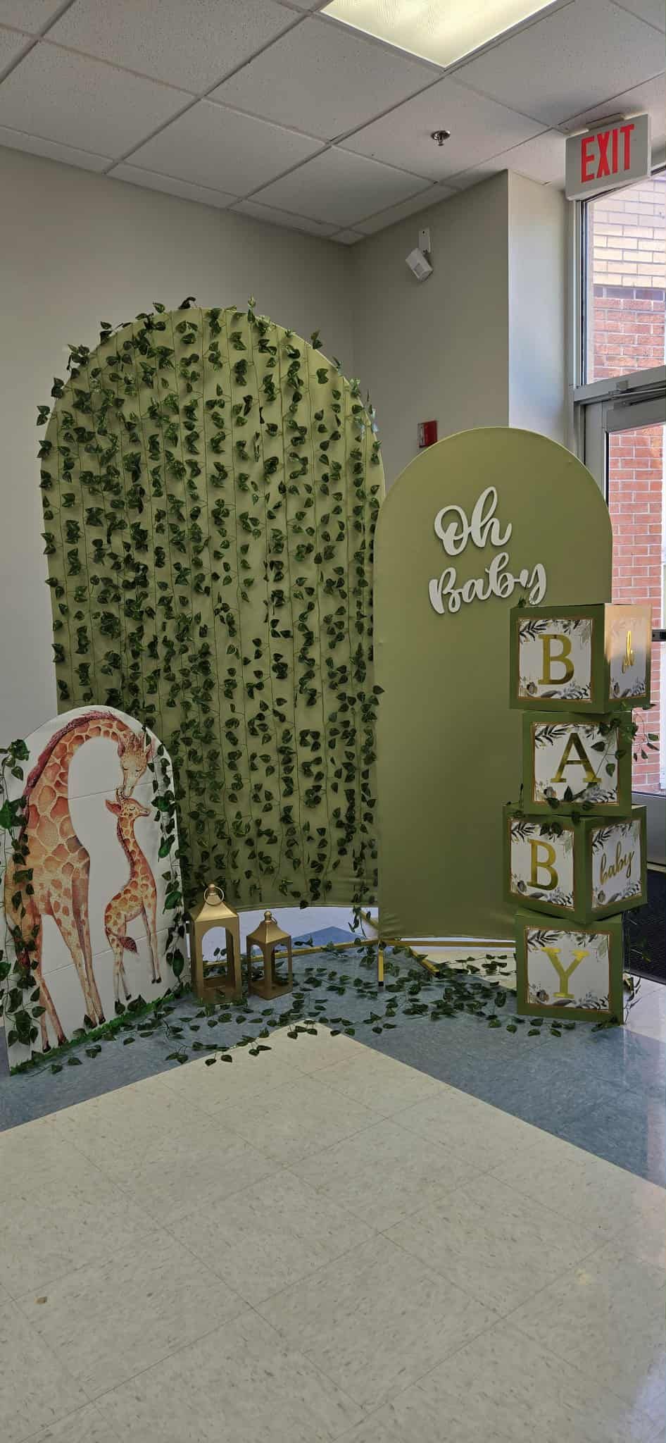 Green vine-covered arc display with a mirror and stacked alphabet blocks in a corner