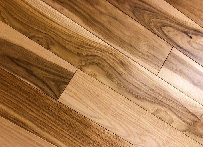 Pavimento in legno con diverse tonalità di marrone, posato in diagonale.