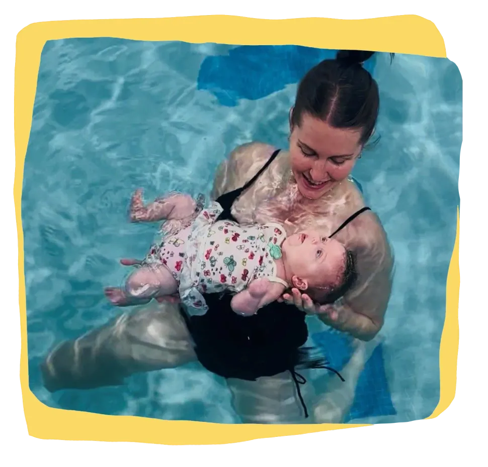 Woman holding a baby in a swimming pool, both floating in blue water.