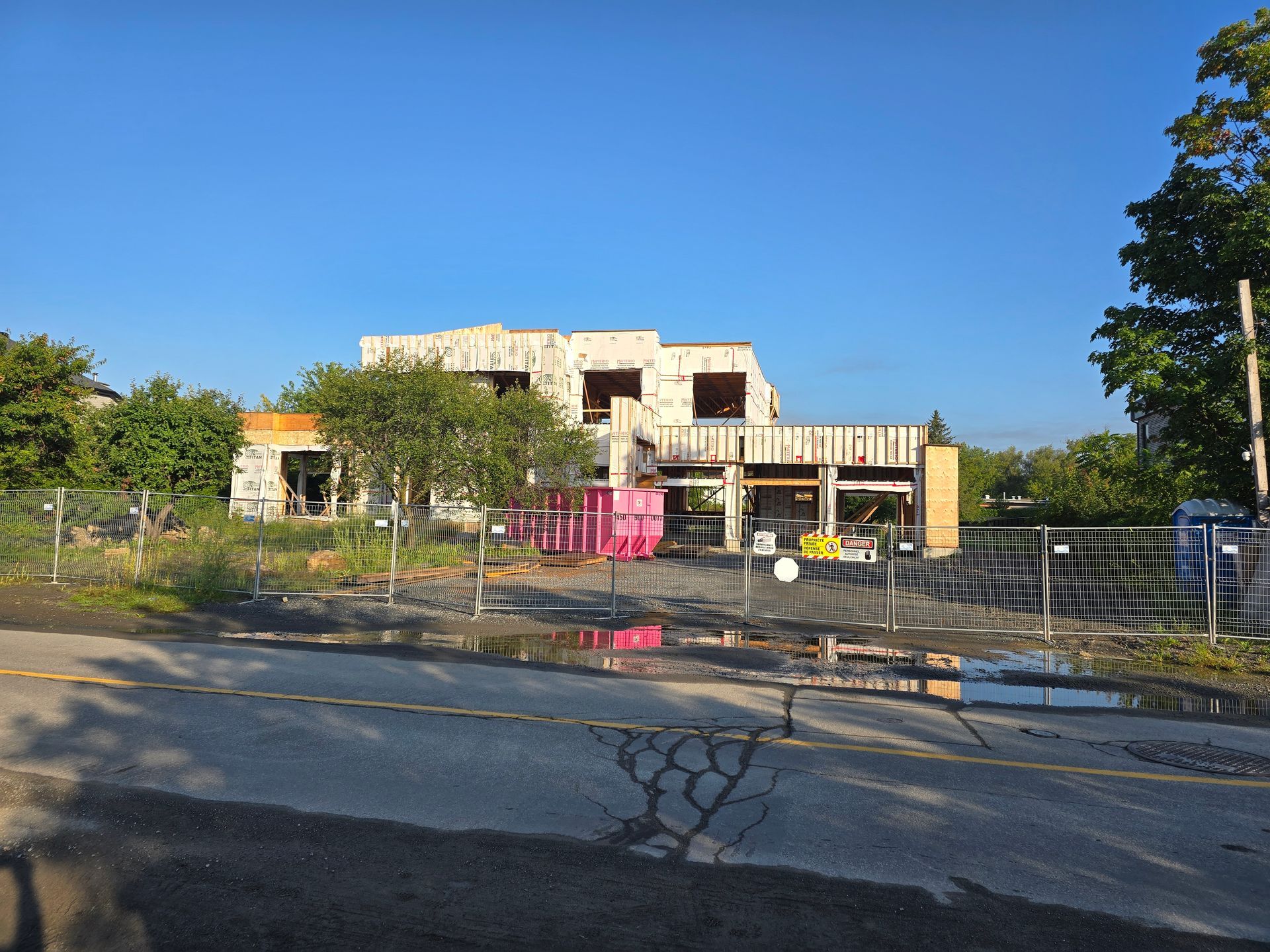 A large house is being built in the middle of a fenced in area