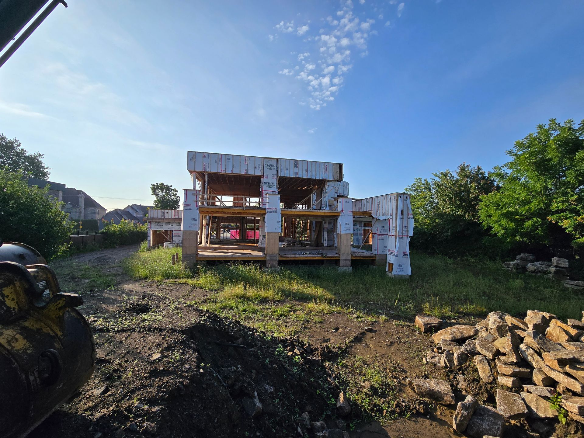 A house is being built in the middle of a dirt field.