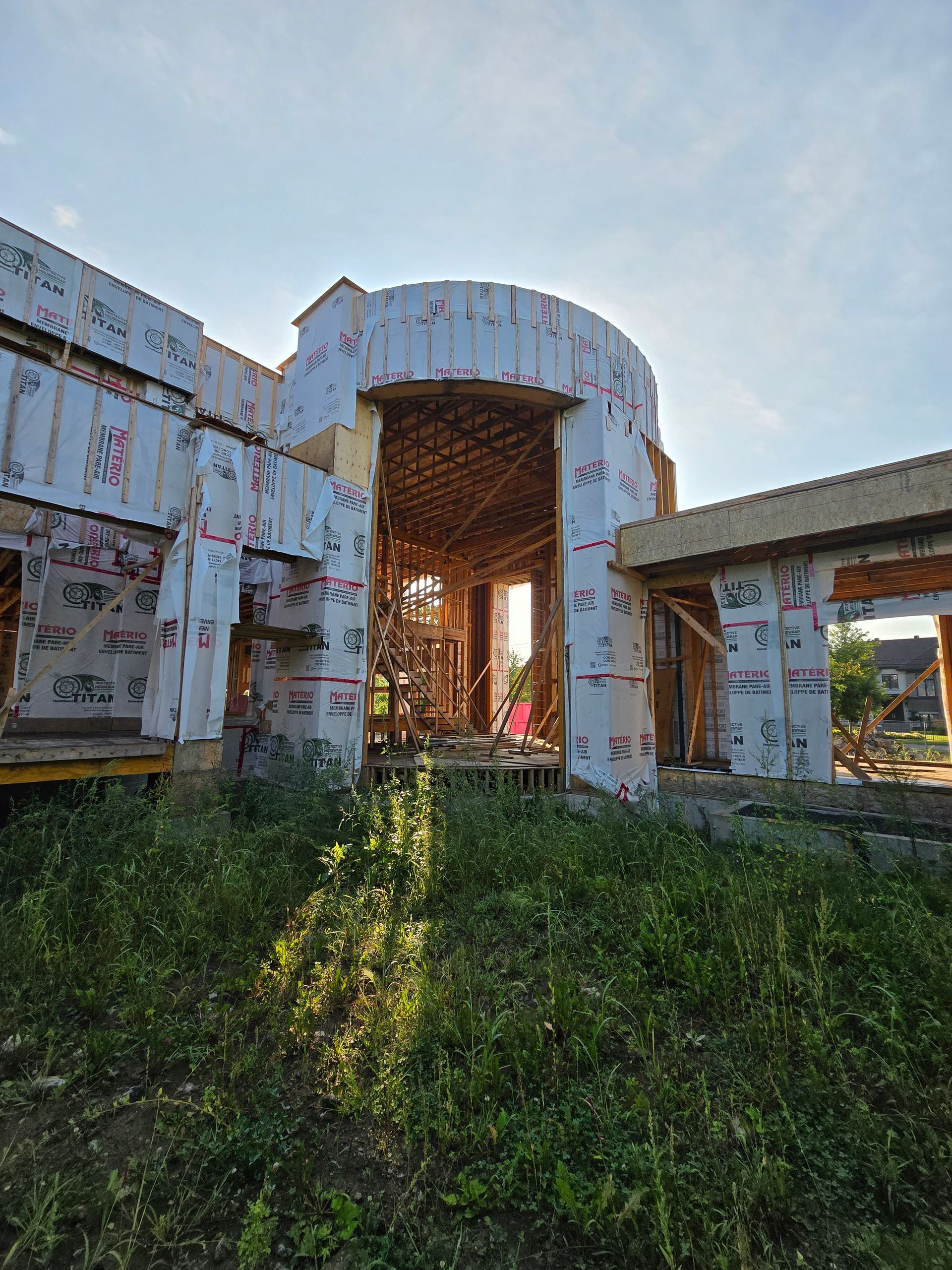 A large building is being built in the middle of a field.