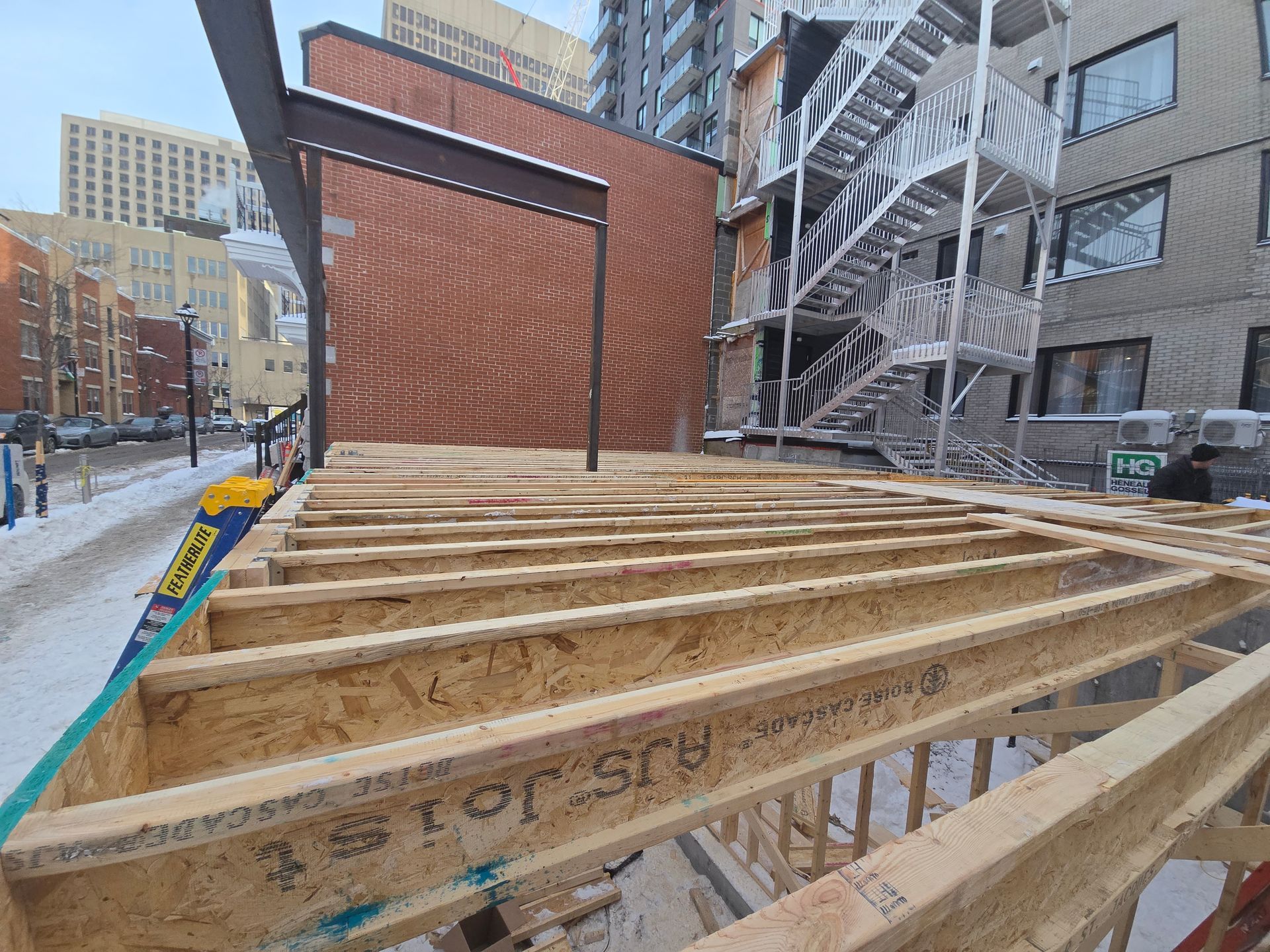 A wooden structure is being built in front of a brick building.