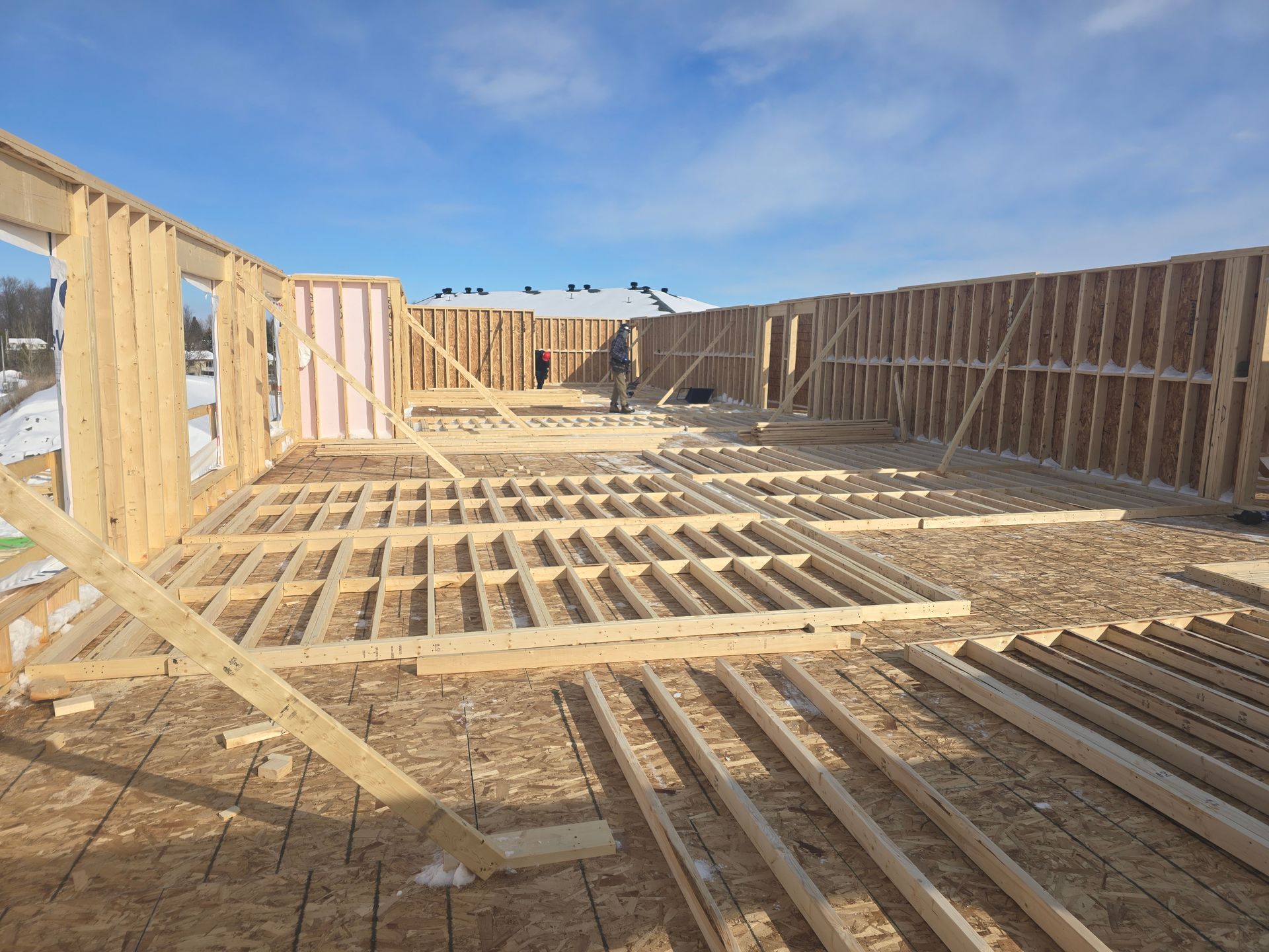 A large wooden structure is being built in the snow.