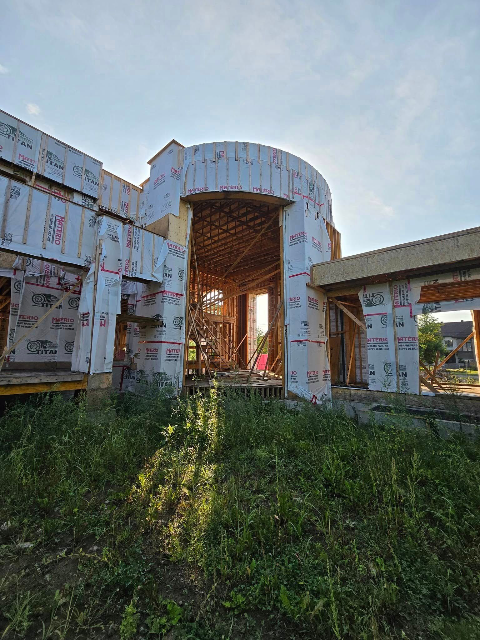 Un grand bâtiment est en construction au milieu d'un champ.