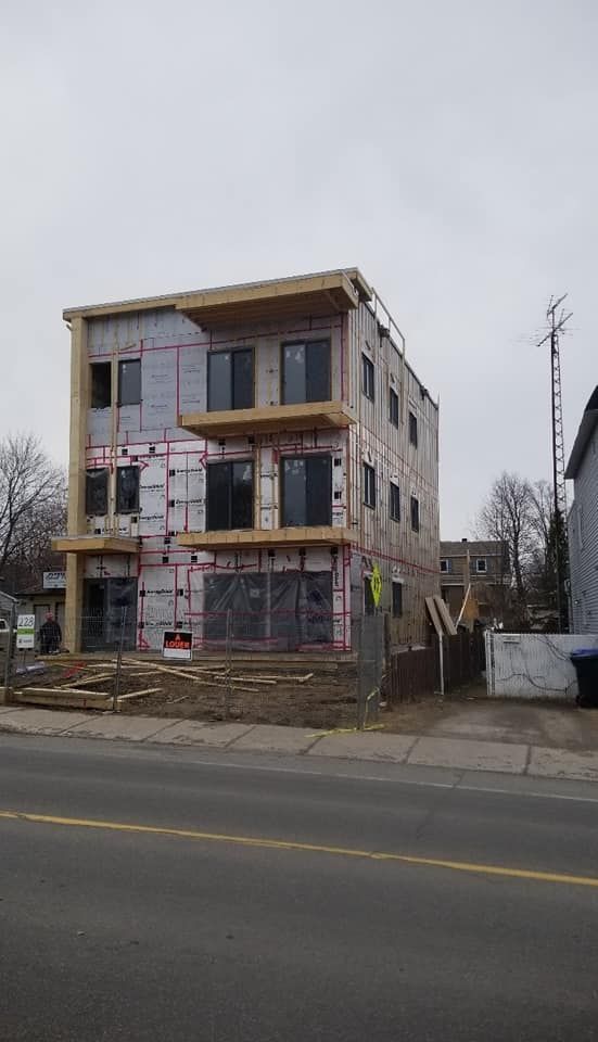 Un grand bâtiment est en construction sur le bord de la route.