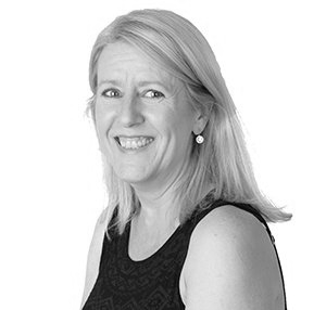 Smiling woman in a sleeveless black top, posed against a white background